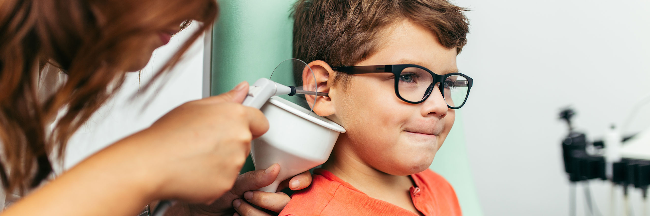 A kid doing an ear exam