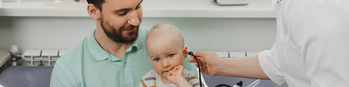 Doctor checking a baby's ear.