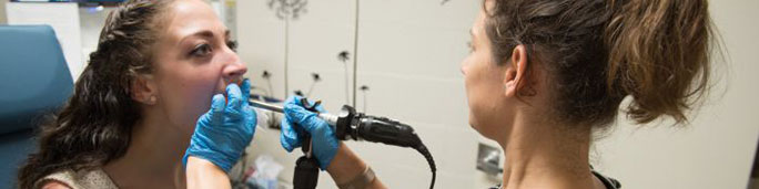 A woman receives a voice and resonance exam.